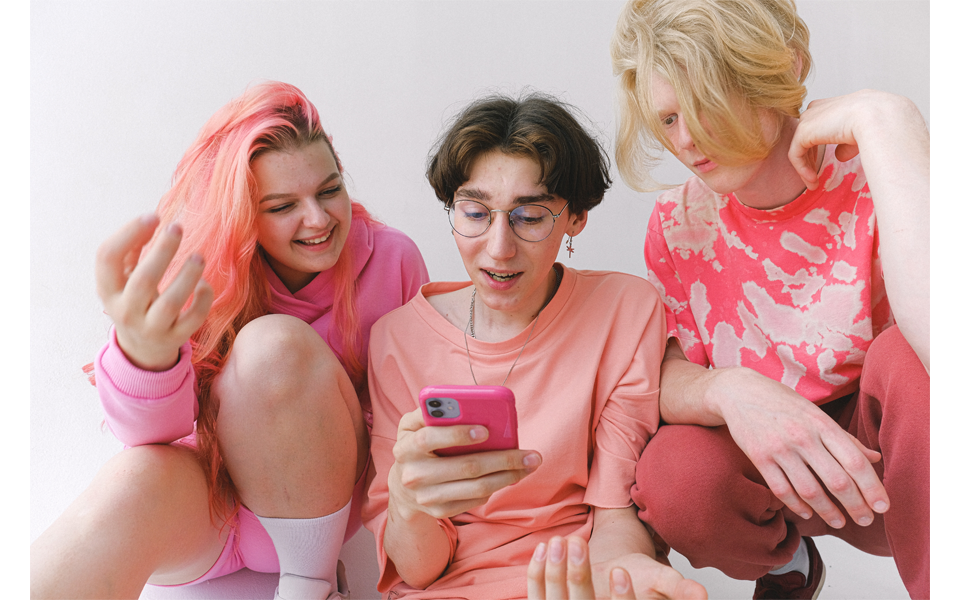 Three young people looking at a mobile phone