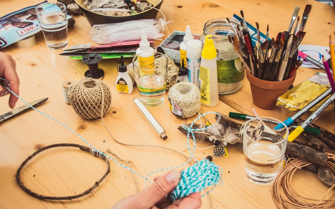 Image of messy arts and crafts supplies on a wooden table.